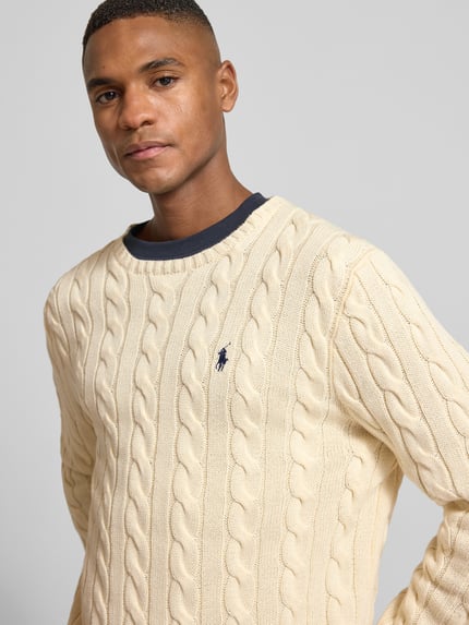 Männermodel trägt Strickpullover mit Label-Stitching von Polo Ralph Lauren aus reiner Baumwolle im Regular-Fit, Nahaufnahme Oberkörper.