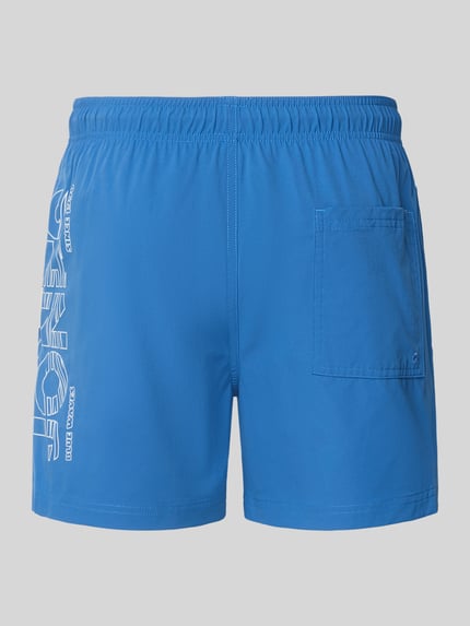 Produktfoto, Badehose mit Label-Print Modell 'MAUI WAVE' von Jack & Jones, Herren Badehose in Regular Fit mit elastischem Bund, leuchtend blau, rechteckige Form, sichtbare Textur durch Label-Print und aufgesetzte Gesäßtasche.