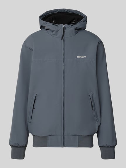 Produktfoto, Segeljacke mit Logo-Stitching und Kapuze von Carhartt Work In Progress in Grau mit Reißverschlusstaschen und gerippten Abschlüssen