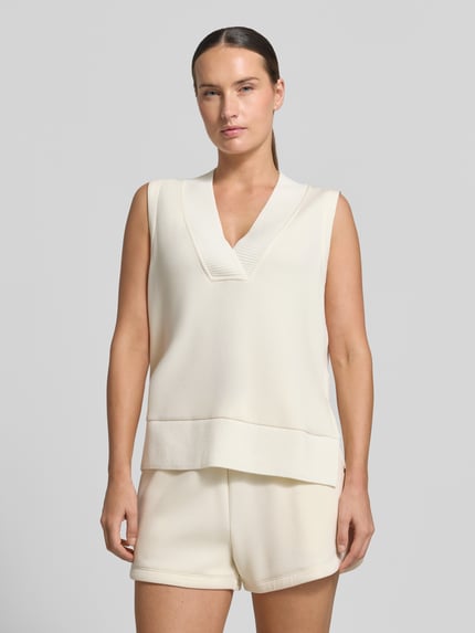 Vrouwenmodel draagt top uit mix van viscose en elastaan in tricotlook Model 'Freida' van VARLEY, los model, V-hals, ribboorden, crème, voorkant geheel lichaam, ruglengte bij maat S 40 cm