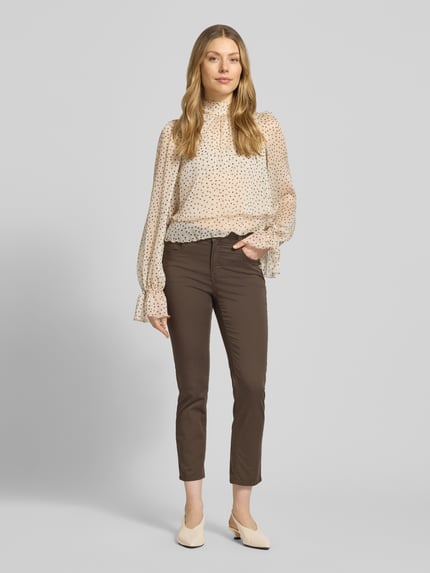 Frauenmodel trägt Hose in verkürzter Passform Modell 'Mary' von Brax aus Baumwoll-Lyocell-Mix mit Eingrifftaschen, Ganzkörperansicht von vorne.