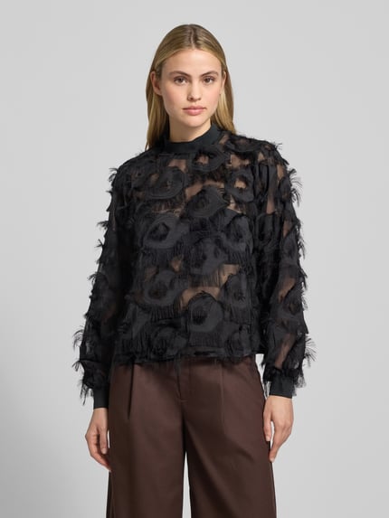 Vrouwenmodel draagt semitransparante blouse met franjes model 'DIO' van YAS, regular fit, zwarte kleur, staande kraag, vooraanzicht bovenlichaam.