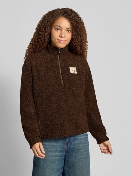 Frauenmodel trägt Troyer mit Teddyfleece-Struktur von PIECES in Braun, unifarben, Label Patch, Reißverschluss, Ganzkörperansicht von vorne.