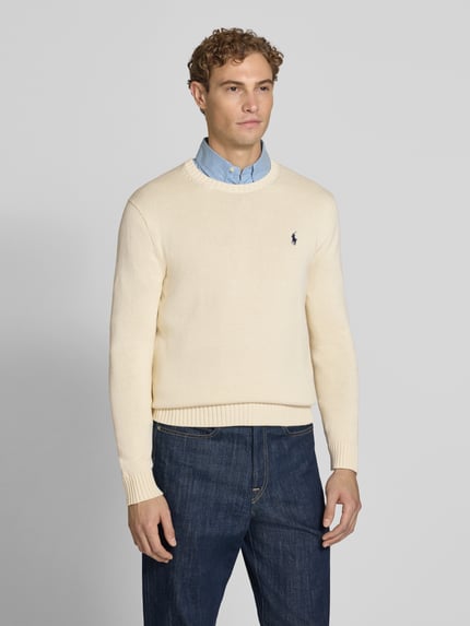 Männermodel trägt Relaxed Fit Pullover aus reiner Baumwolle von Polo Ralph Lauren in Beige, strukturierte Oberfläche, Ganzkörperansicht von vorne. Herren Pullover von Polo Ralph Lauren.