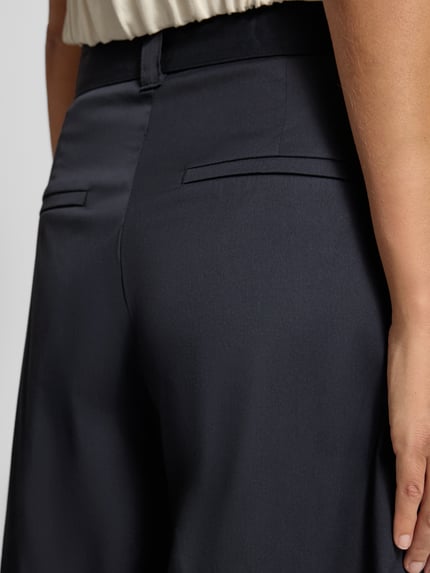 Frauenmodel trägt Wide Leg Hose mit Gürtel Modell 'Carletta' von MAC aus dunkelblauem Baumwoll-Mix mit Stretch-Anteil, Detailaufnahme Rückansicht.