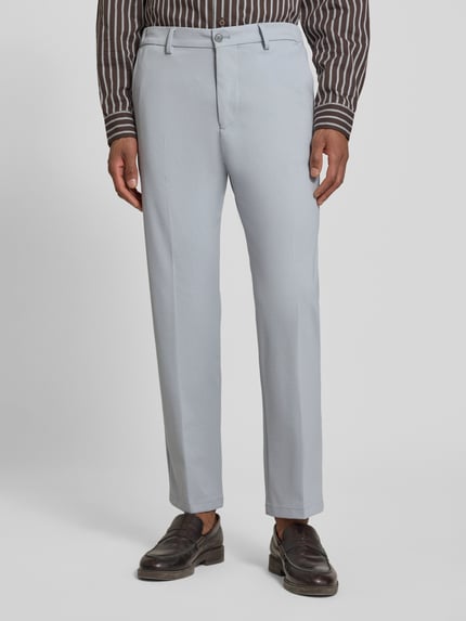Männermodel trägt helle Straight Fit Stoffhose mit Bügelfalten Modell 'Ajend' von Drykorn, elastischer Baumwoll-Mix, Nahaufnahme Oberkörper.