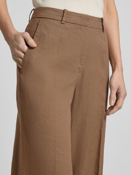 Frauenmodel trägt Hose aus Leinen-Mix mit Bügelfalten Modell 'MIRA' von Cambio in Braun, Regular-Fit, Nahaufnahme Oberkörper. Damen Hose mit Baumwoll-Anteil, strukturierte Oberfläche, Bundweite 38 cm, Innenbeinlänge 85 cm, Größe 36.