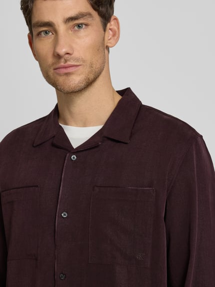 Männermodel trägt Hemdjacke mit Knopfleiste von CK Calvin Klein aus reinem Lyocell, lockerer Schnitt, Nahaufnahme Oberkörper.