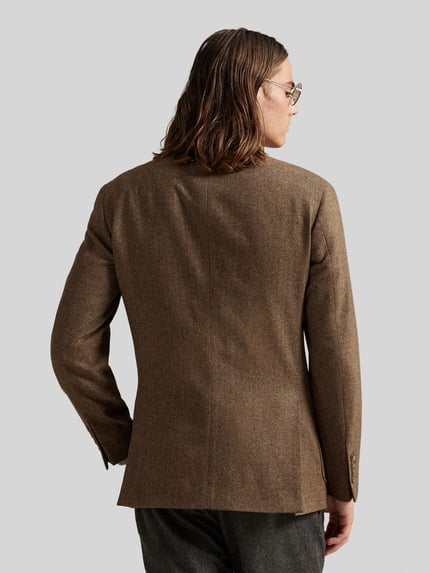 Mannenmodel draagt Regular Fit Anzugsakko mit Woll-Anteil van Polo Ralph Lauren in melange bruin, lange mouwen, reverskraag, een enkele knoopsluiting, label-applicatie, volledige lichaamsweergave achterkant.