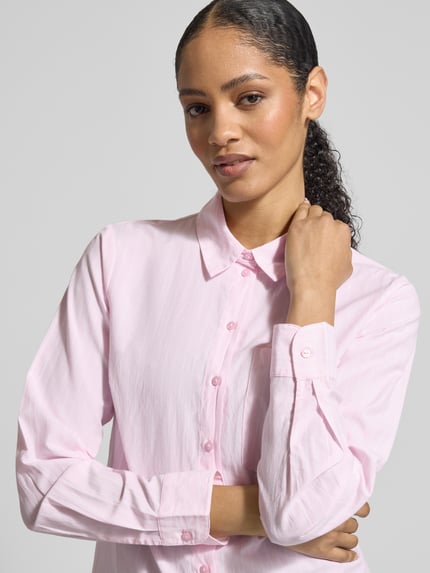 Frauenmodel trägt Regular Fit Hemdbluse mit Brusttasche Modell 'Darma' von Vila in zartem Rosa, Baumwoll-Mix, Nahaufnahme Oberkörper.