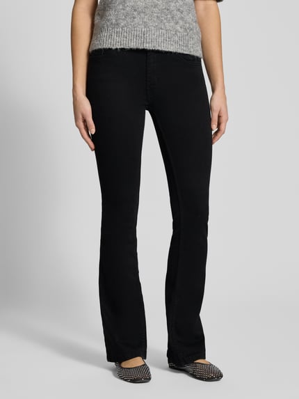 Frauenmodel trägt Flared Jeans mit mittelhohem Bund von Review, schwarze Waschung, 5-Pocket-Design, Nahaufnahme Unterkörper.