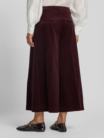 Frauenmodel trägt weite, bordeauxrote Cordhose aus reiner Baumwolle Modell 'MELLI S' von Brax, Damen Weite Hose, Ganzkörperansicht Rückansicht.