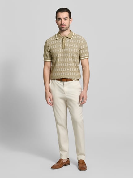 Männermodel trägt Regular Fit Poloshirt im Allover-Look von Jack & Jones Premium, beige Muster, reine Baumwolle, Ganzkörperansicht von vorne.