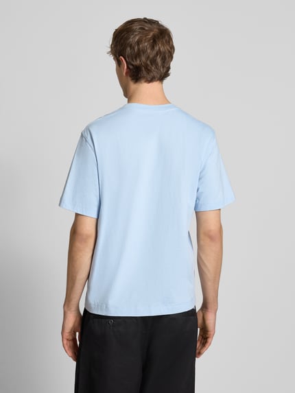 Männermodel trägt T-Shirt mit Label-Stitching Modell 'NORREBRO' von Jack & Jones in Hellblau, reine Baumwolle, Ganzkörperansicht Rückansicht.