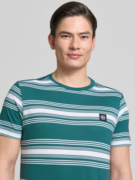 Männermodel trägt T-Shirt mit Label-Patch und Rundhalsausschnitt von Lerros, grün-weiß gestreift, Reine Baumwolle, Regular-Fit, Nahaufnahme Oberkörper. Rückenlänge bei Größe M 72 cm.