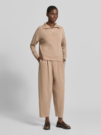 Frauenmodel trägt Troyer mit Stehkragen und Reißverschluss von Christian Berg Woman in Beige, Material-Mix mit Modal-Anteil, Regular Fit, Ganzkörperansicht von vorne.