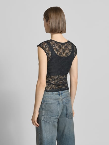 Vrouwenmodel draagt T-shirt uit Spitze met Raffung aan de Seitennaht van REVIEW, zwarte kant, nauwsluitende pasvorm, ruglengte maat S 45 cm, elastische materiaalmix, ronde hals, ganzkörperansicht rückansicht.