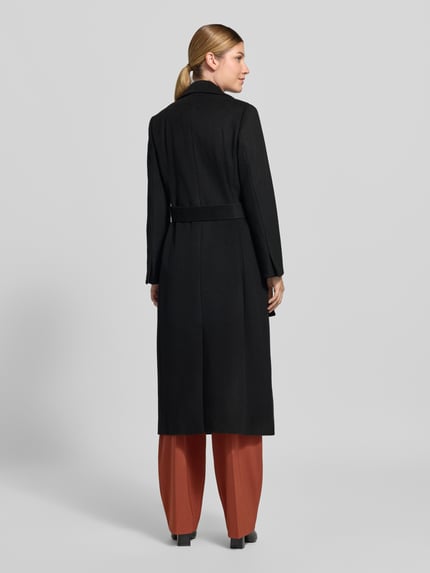 Frauenmodel trägt Regular Fit Mantel aus reiner Schurwolle Modell 'LONGRUN' von MAX&Co. in Schwarz, glatte Textur, Ganzkörperansicht Rückansicht.