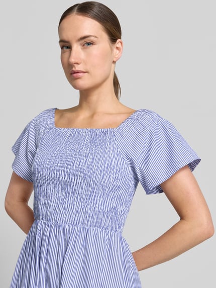Frauenmodel trägt Midikleid mit Smok-Details Modell 'INZI' von B.Young aus Baumwoll-Mix mit Karree-Ausschnitt, taillierter Schnitt, Nahaufnahme Oberkörper. Rückenlänge bei Größe 36: 109 cm, Brustweite: 36 cm, Ärmellänge: 21 cm. Streifenmuster in Blau und Weiß.