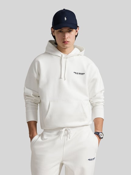 Männermodel trägt Relaxed Fit Hoodie aus Baumwoll-Mix von Polo Ralph Lauren in Unifarben Weiß mit Label-Schriftzug, Ganzkörperansicht von vorne.