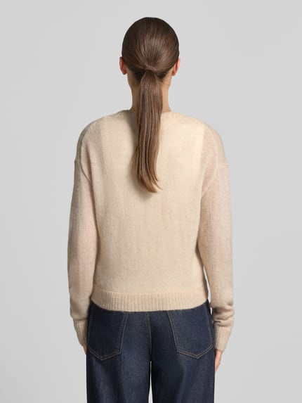 Frauenmodel trägt Strickjacke mit Woll-Anteil von COMMA in Beige mit gerippten Abschlüssen, taillierte Passform, Ganzkörperansicht Rückansicht.