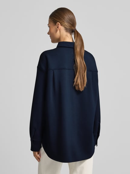 Frauenmodel trägt Regular Fit Longblazer aus Viskosemix von TOM TAILOR in dunkelblau mit strukturierter Oberfläche, Ganzkörperansicht Rückansicht.