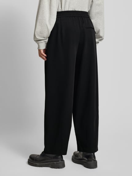 Frauenmodel trägt Loose Fit Bundfaltenhose mit Viskose-Anteil Modell 'MARIELA LIFE' von ONLY, Optik: Unifarben, Bundfalte, elastischer Bund, seitliche Eingrifftaschen, Ganzkörperansicht Rückansicht