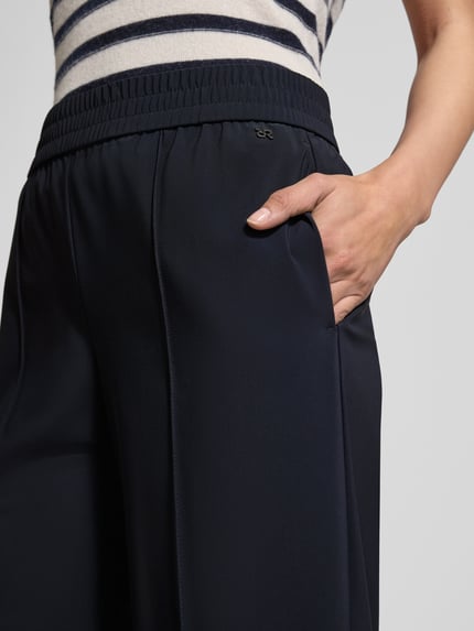 Frauenmodel trägt Hose mit elastischem Bund Modell 'COSMEA' von Raffaello Rossi aus Material-Mix mit Stretch-Anteil, Nahaufnahme Oberkörper.