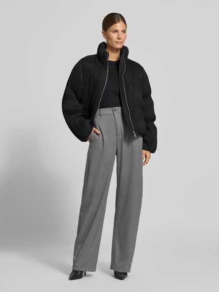 Frauenmodel trägt Steppjacke mit Zweiwege Reißverschluss von YAS, unifarben matt, strukturierte Optik, Ganzkörperansicht von vorne.