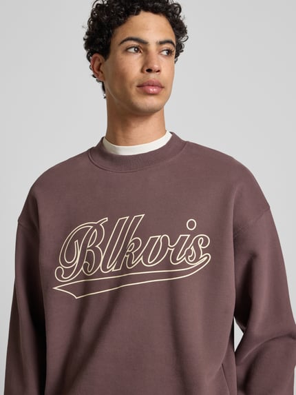 Männermodel trägt Regular Fit Sweatshirt mit Logo-Print Modell 'Source' von BLKVIS aus reiner Baumwolle, Nahaufnahme Oberkörper.