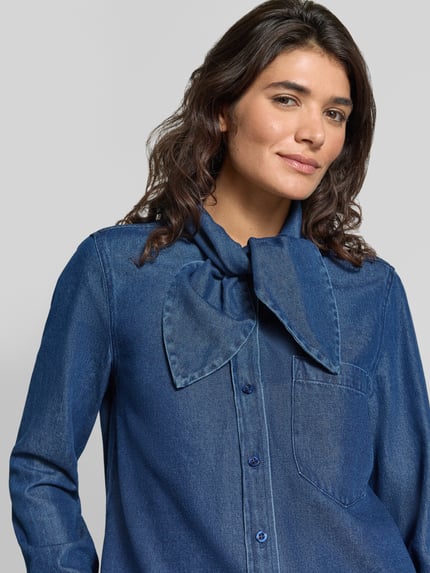 Frauenmodel trägt Jeansbluse mit Schluppe und Brusttasche von Christian Berg Woman im Regular Fit, Baumwoll-Mix, Nahaufnahme Oberkörper.