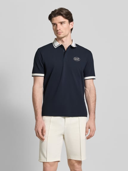 Männermodel trägt Regular Fit poloshirt mit logoprint von EA7 Emporio Armani aus katoenmix, polokraag, met korte mouwen, ruglengte maat M 68 cm. Ganzkörperansicht von vorne