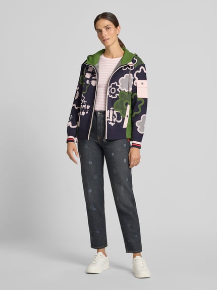 Frauenmodel trägt Slim Fit Longsleeve aus Baumwoll-Mix von Marc Cain, florale Details, Rundhalsausschnitt, Ganzkörperansicht von vorne.