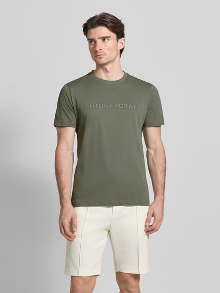 Mannelijk model draagt t-shirt met labelprint van Antony Morato, puur katoen, recht model, ronde hals, ruglengte maat M 72 cm, vooraanzicht.