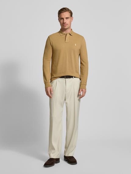 Männermodel trägt Poloshirt mit Label-Stitching von Polo Ralph Lauren in Beige, Regular Fit, reine Baumwolle, Ganzkörperansicht von vorne.