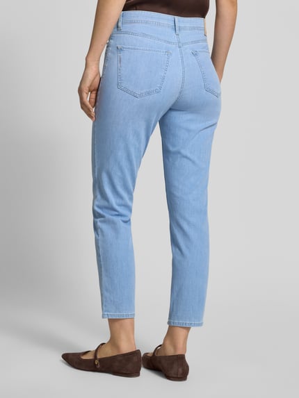 Frauenmodel trägt Jeans in verkürzter Passform Modell 'Mary' von Brax, hellblauer Baumwoll-Mix mit Stretch, Eingrifftaschen, Ganzkörperansicht Rückansicht.