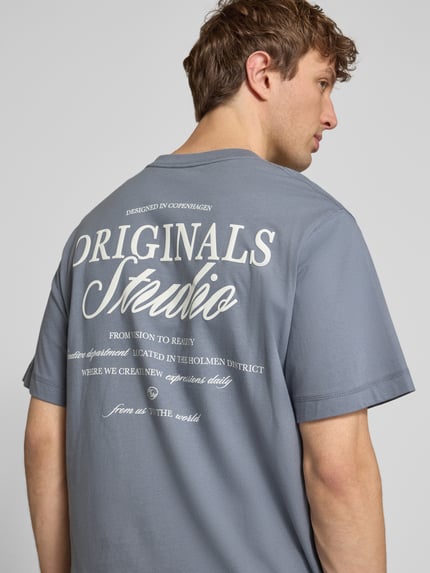 Männermodel trägt Herren T-Shirt mit Statement-Print Modell 'NORREBRO' von Jack & Jones aus Reine Baumwolle in Grau, Gerader-Schnitt, Rückenansicht, Detailaufnahme.