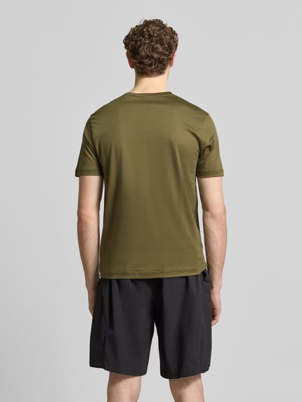 Männermodel trägt Regular Fit T-Shirt aus reiner Baumwolle Modell 'PS Spirit 70 Grx' von BOSS Green X PORSCHE in Olive, unifarben, Ganzkörperansicht Rückansicht.
