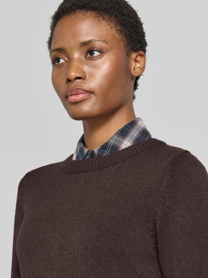 Frauenmodel trägt Strickpullover aus Viskose-Mix von VILA in Dunkelbraun, gerippter Rundhalsausschnitt, Nahaufnahme Oberkörper.