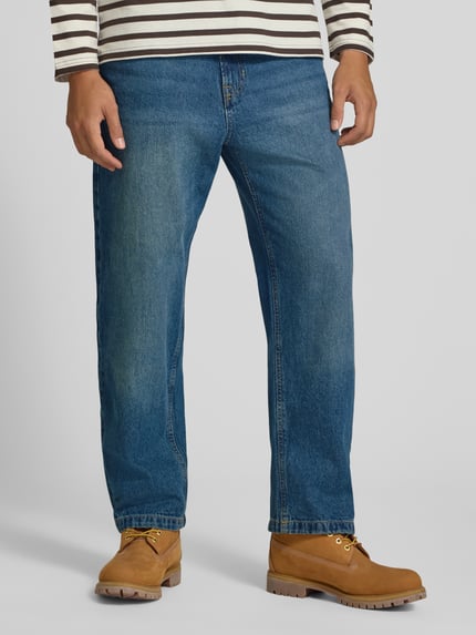 Männermodel trägt Straight Fit Jeans aus reiner Baumwolle mit Gürtelschlaufen von JACK & JONES, niebieski kolor, pięciokieszeniowy, zapięcie na guzik i zamek, szerokość w rozmiarze 32/32: 42 cm, długość nogawki od wewnątrz w rozmiarze 32/32: 75 cm, widok całej sylwetki z przodu