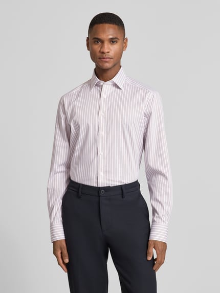Männermodel trägt Regular Fit Businesshemd aus Baumwolle mit Kentkragen von OLYMP, weiß-rosa gestreift, glatte Textur, Ganzkörperansicht von vorne.