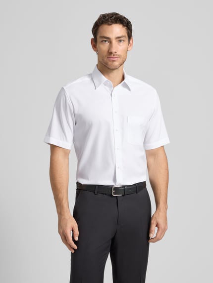 Männermodel trägt Regular Fit Business-Hemd aus Baumwolle mit Kentkragen von ETERNA, Weiß, Brusttasche, Ganzkörperansicht von vorne. Rückenlänge bei Größe 40: 80 cm, Schulterbreite bei Größe 40: 45 cm, Ärmellänge bei Größe 40: 28 cm.