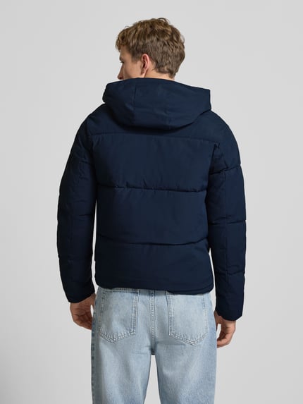 Männermodel trägt Steppjacke mit Kapuze Modell 'GALAXY' von JACK & JONES in Dunkelblau, strukturierte Oberfläche, Rückenansicht, Ganzkörperansicht Rückansicht. Regular Fit, Reißverschluss, Eingrifftaschen, moderate Schulterbreite und Ärmellänge.