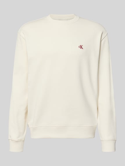 Produktfoto, Sweatshirt aus reiner Baumwolle von Calvin Klein Jeans in Cremeweiß mit gerippten Abschlüssen und Label-Stitching auf glatter Oberfläche.