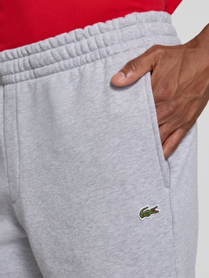 Männermodel trägt Relaxed Fit Sweatshorts aus Baumwoll-Mix von Lacoste in Hellgrau, Herren Sweatshorts, Nahaufnahme Oberkörper