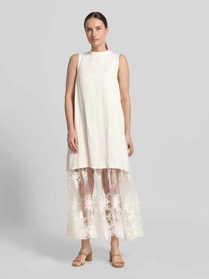 Frauenmodel trägt Relaxed-Fit Maxikleid aus Viskose-Mix Modell 'Tenley' von Copenhagen Muse mit Spitzenbesatz, cremefarben, Ganzkörperansicht von vorne.