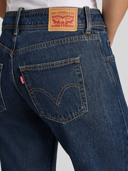 Frauenmodel trägt Straight Fit Jeans aus reiner Baumwolle Modell 'SUPERLOW' von Levi's®, blaue Farbe, strukturierte Denim-Oberfläche, Nahaufnahme Rückansicht, Damen Straight Fit Jeans von Levi's®.