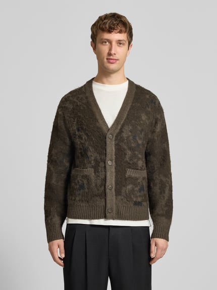 Männermodel trägt Cardigan mit Knopfleiste von ONLY in marmorierter Strickoptik, V-Ausschnitt, gerippte Abschlüsse, Ganzkörperansicht von vorne.