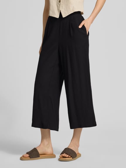 Vrouwenmodel draagt Regular Fit Culotte uit viscose-linnenmix model 'MYMILO' van Vero Moda, effen zwart, flammé structuur, met elastische tailleband en steekzakken, zijaanzicht close-up van de benen.