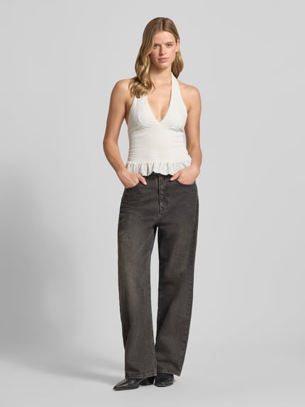Frauenmodel trägt Neckholder-Blusentop mit V-Ausschnitt von Gina Tricot, Material-Mix mit Stretch-Anteil, Taillierter Schnitt, Smok-Detail, Weiß, strukturierte Textur, Rückenlänge bei Größe S: 53 cm, Ganzkörperansicht von vorne.